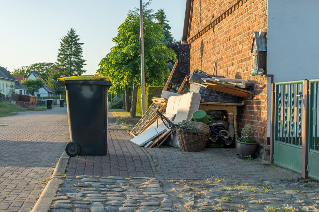 A pile of old furniture and residential junk on a curb awaiting a haul-away and debris removal service.